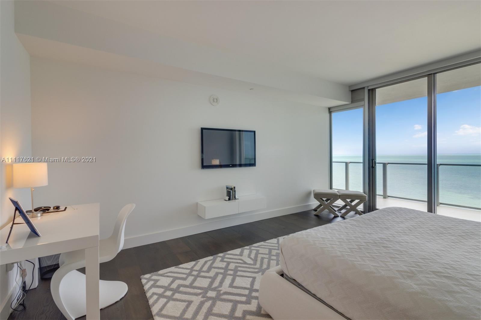 360 Ocean Drive, Unit 1106S Key Biscayne, FL 33149 - Photo 17 of 35 a large bedroom with a bed and wooden floor