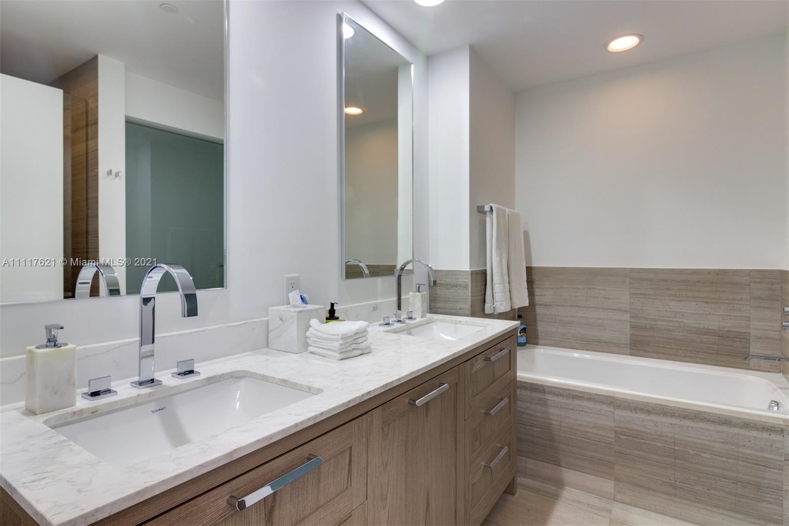 360 Ocean Drive, Unit 1106S Key Biscayne, FL 33149 - Photo 18 of 35 a bathroom with a double vanity sink and a bathtub