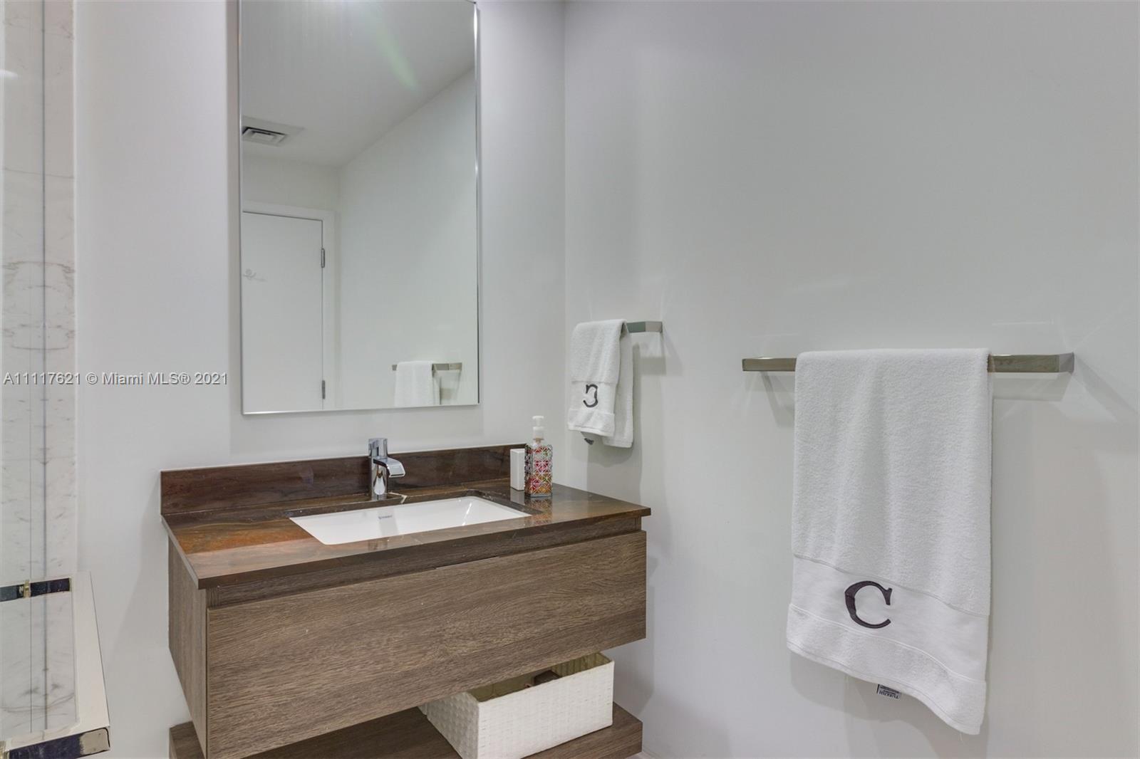 360 Ocean Drive, Unit 1106S Key Biscayne, FL 33149 - Photo 21 of 35 a bathroom with a granite countertop sink and a mirror