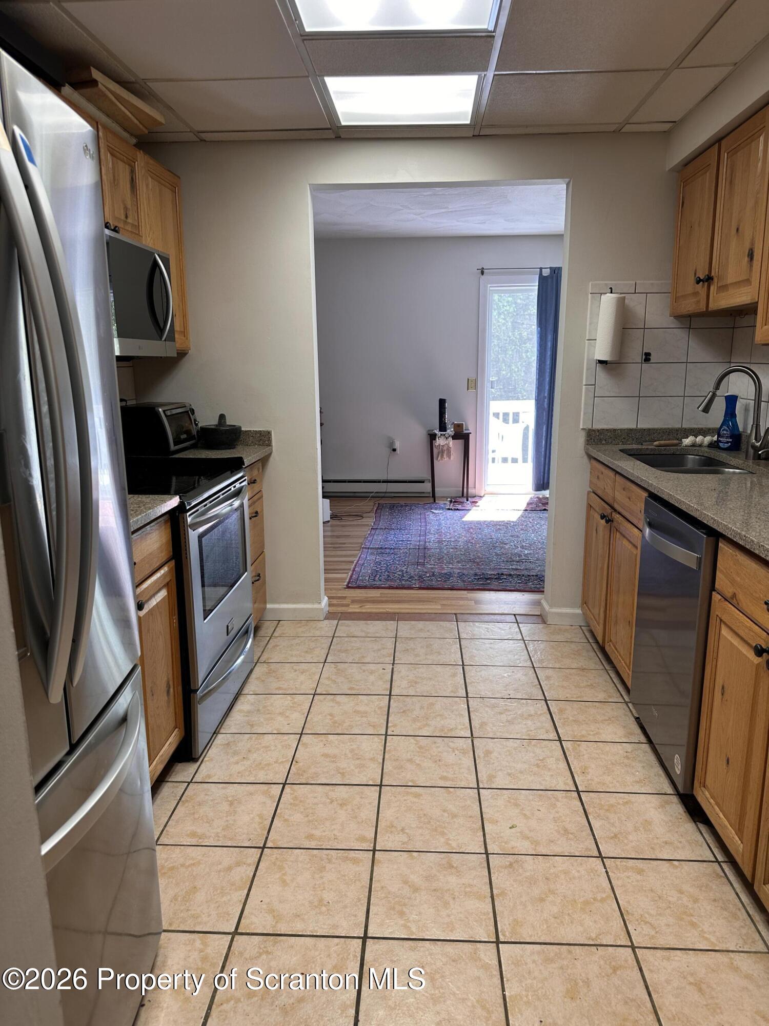 107 Keystone Hls Road, Unit 405 Factoryville, PA 18419 - Photo 10 of 27 a kitchen with stainless steel appliances granite countertop a stove a sink and a refrigerator