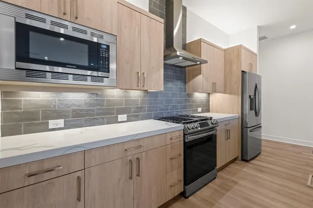 a kitchen with stainless steel appliances white cabinets and a stove top oven