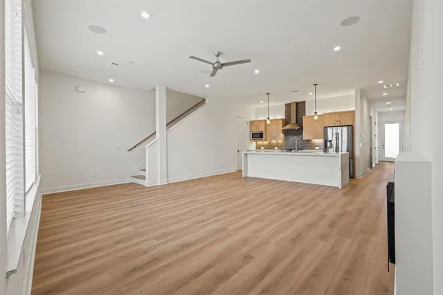 a view of a kitchen with wooden floor and a ceiling fan