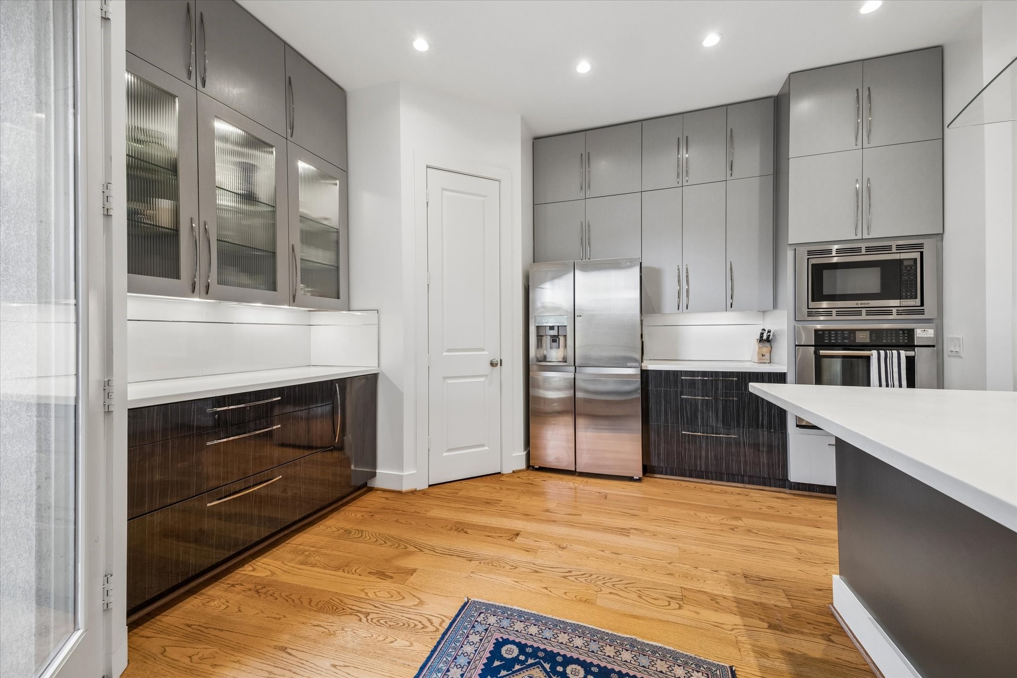 1518 West Clay Street Houston, TX 77019 - Photo 16 of 36 Another kitchen view showing glass & solid front cabinetry, entry to spacious walk-in pantry and far left door to back porch overlooking the beautiful garden.
