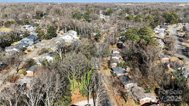 an aerial view of residential house with yard and trees