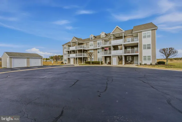 a view of residential houses with cars parked in front of it