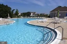 a view of a swimming pool with a patio and a yard