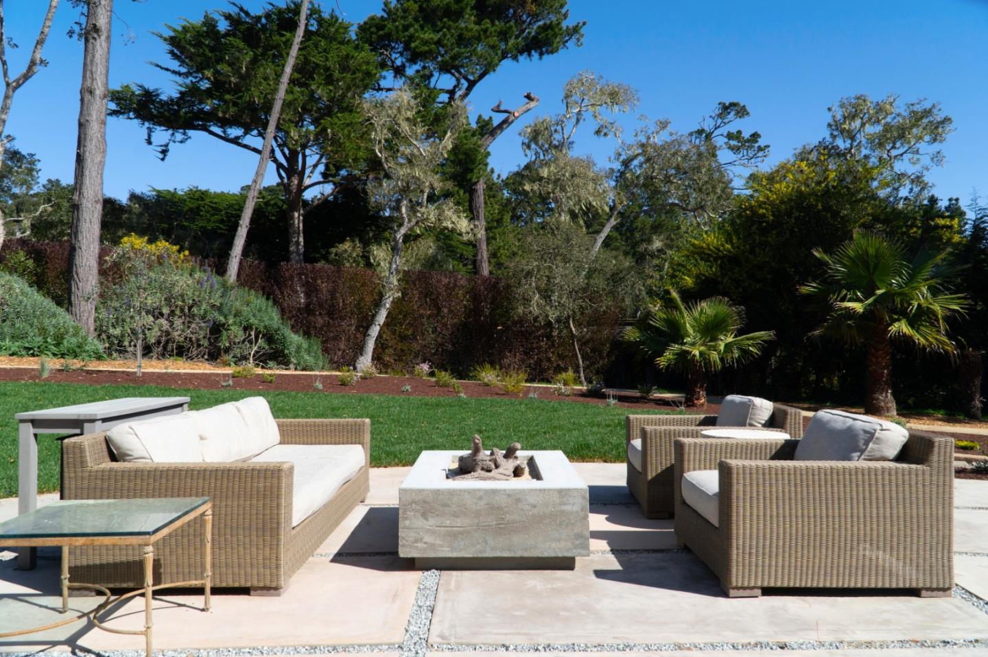 1505 Venadero Road Pebble Beach, CA 93953 - Photo 31 of 36 a view of a patio with couches and a table and chairs with plants and trees