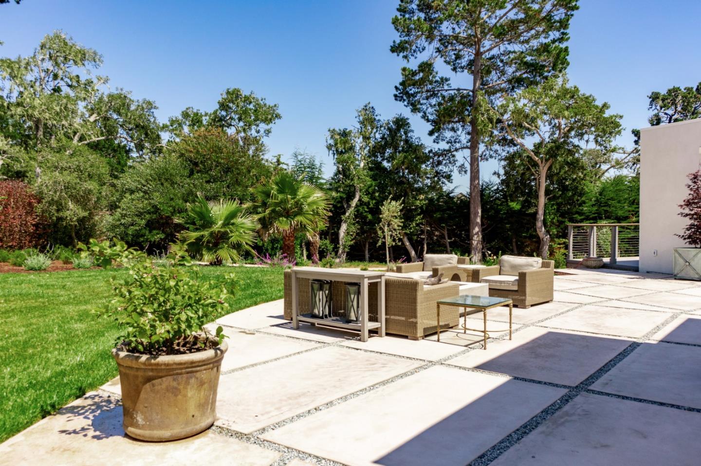 1505 Venadero Road Pebble Beach, CA 93953 - Photo 32 of 36 a view of a patio with table and chairs potted plants and large tree