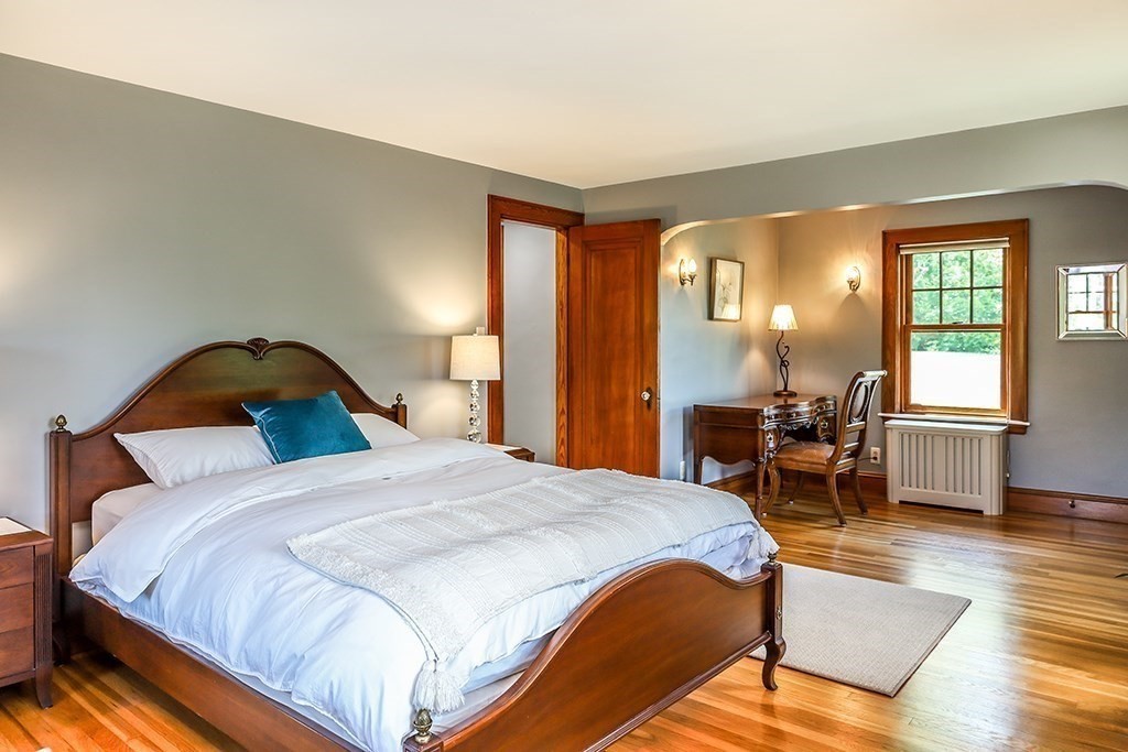 26 Windsor Road Westwood, MA 02090 - Photo 21 of 41 a spacious bedroom with a bed a table and chair with the wooden floor