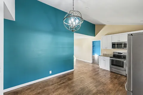 a view of a kitchen with stainless steel appliances a refrigerator and a stove top oven