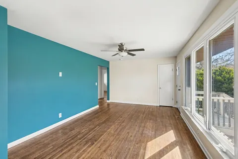 a view of a room with a ceiling fan and a large window
