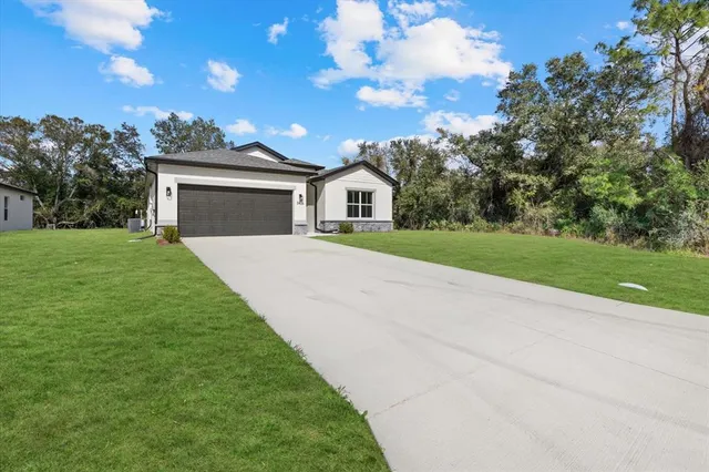 a front view of a house with a yard and garage