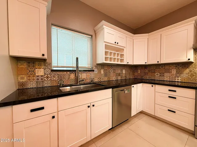 a kitchen with granite countertop white cabinets and white appliances