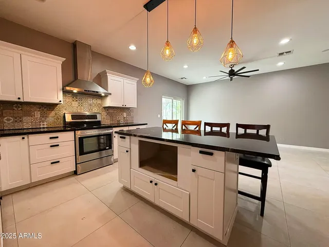 a kitchen with stainless steel appliances granite countertop a stove a sink and a refrigerator