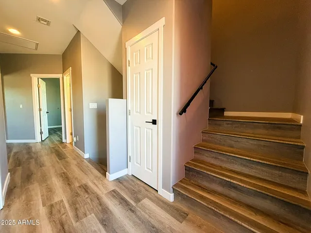 a view of a hallway with wooden floor and staircase