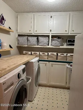 a utility room with granite countertop cabinets and washer