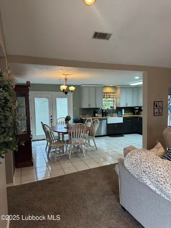 a living room with furniture and a dining table with kitchen view