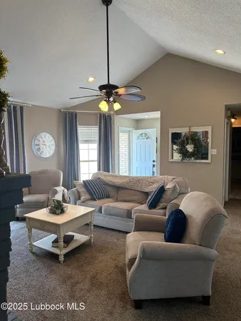 a living room with furniture a chandelier and a window