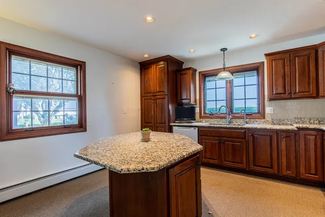 a kitchen with granite countertop sink stove and granite counter top