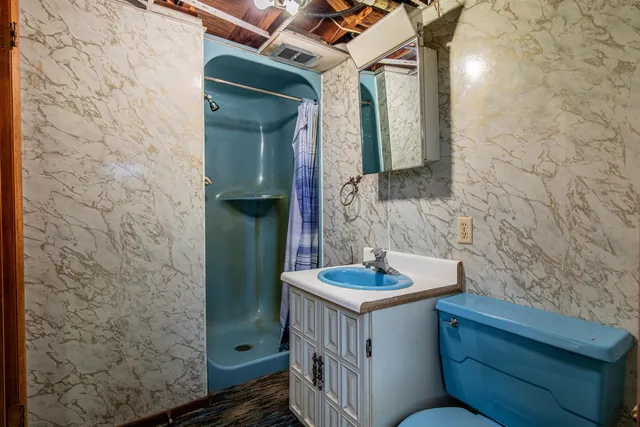 a bathroom with a sink a toilet and shower