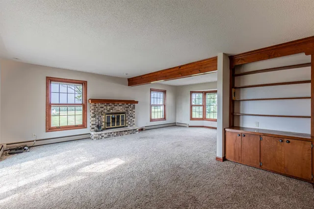 an empty room with a fireplace and window