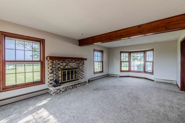 a view of a livingroom with a fireplace and windows