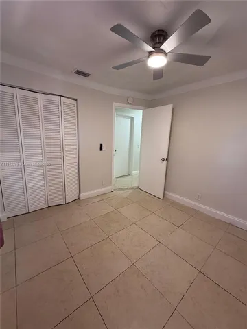 a view of a livingroom with a ceiling fan & cabinets
