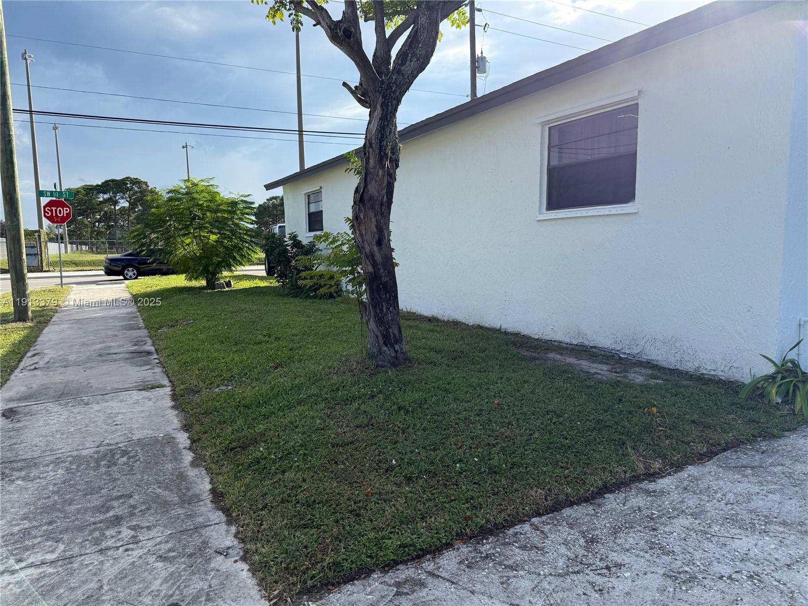 601 Southwest 10th Street Delray Beach, FL 33444 - Photo 17 of 17 a front view of a house with a yard and potted plants