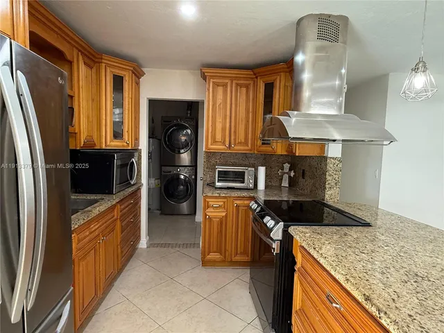 a kitchen with stainless steel appliances granite countertop a refrigerator a stove and a sink