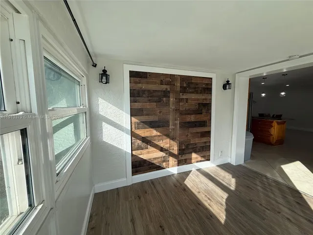 a view of a bedroom with wooden floor and windows