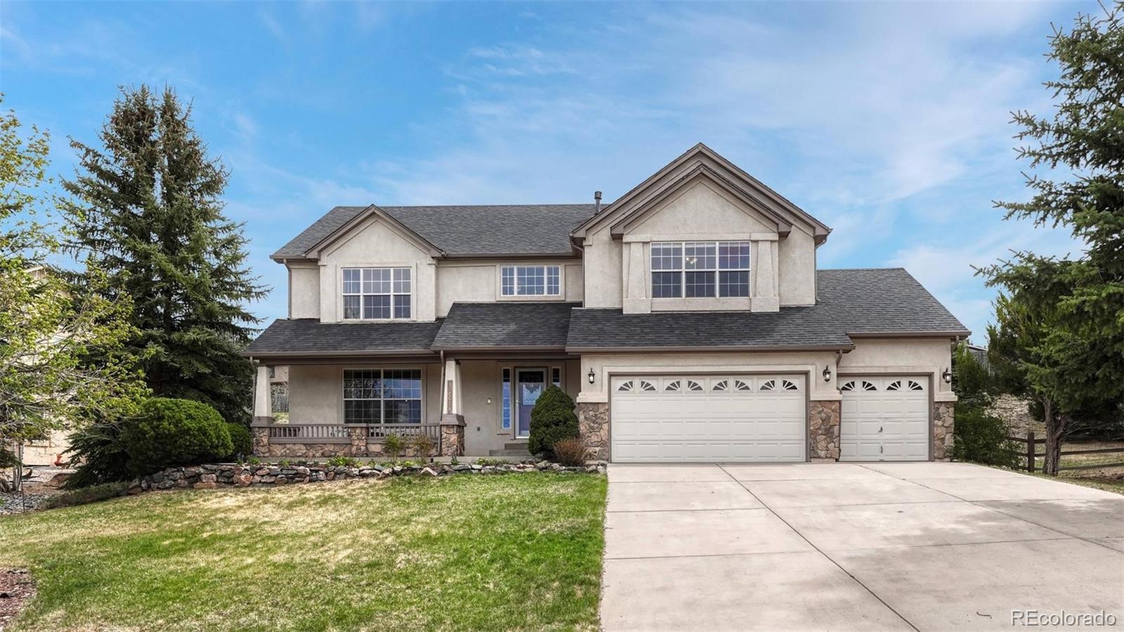 15211 Ridgefield Lane Colorado Springs, CO 80921 - Photo 1 of 47 a front view of a house with a yard and garage