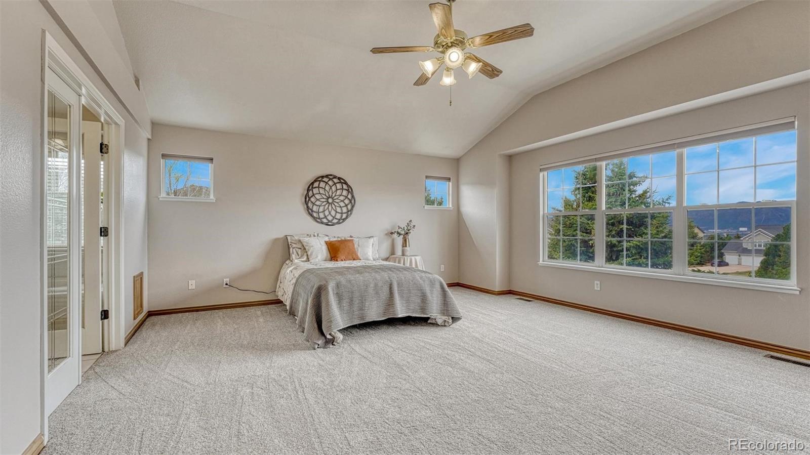 15211 Ridgefield Lane Colorado Springs, CO 80921 - Photo 18 of 47 a bedroom with a large bed and a large window