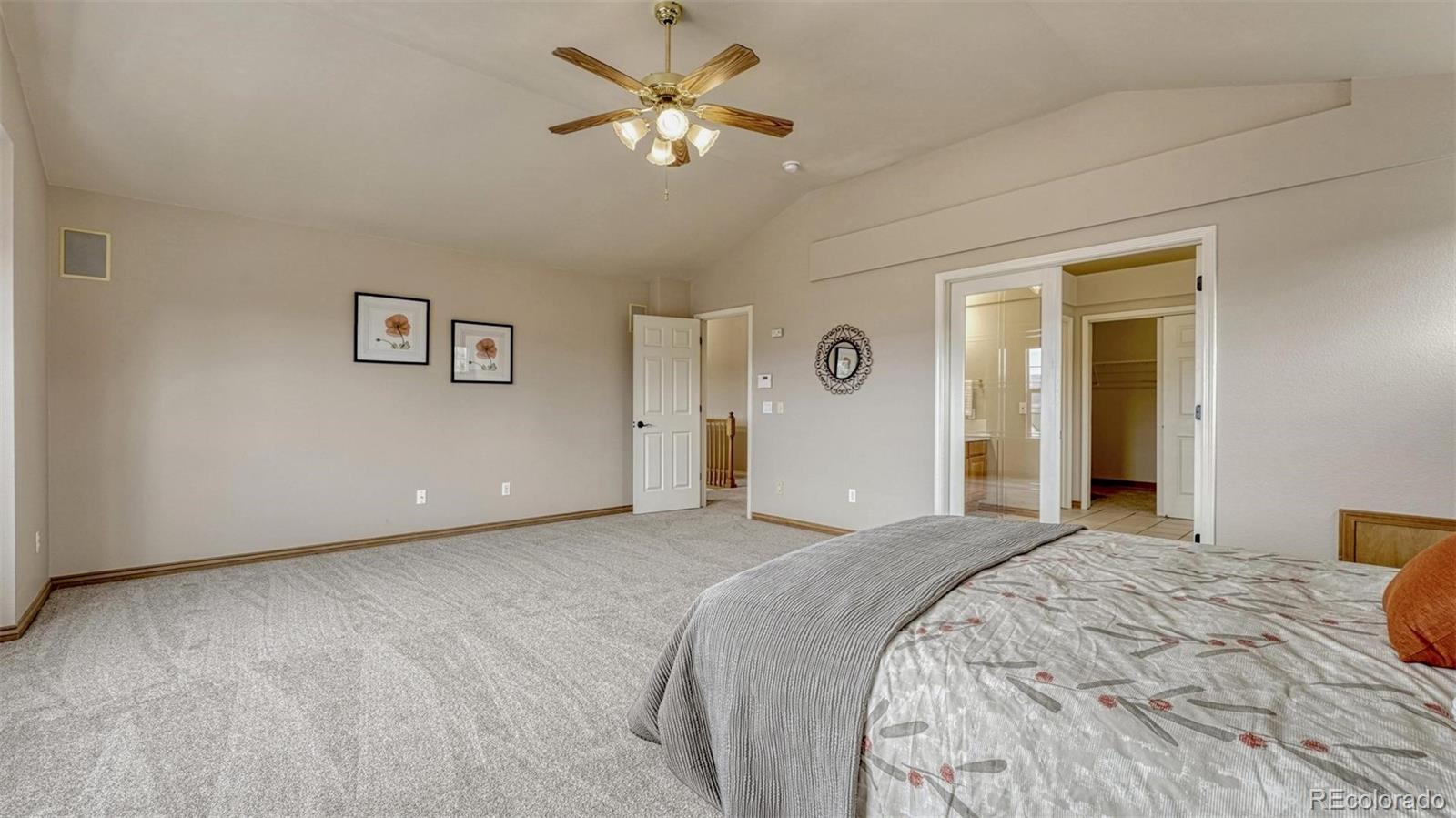 15211 Ridgefield Lane Colorado Springs, CO 80921 - Photo 20 of 47 a bedroom with a large bed and a chandelier