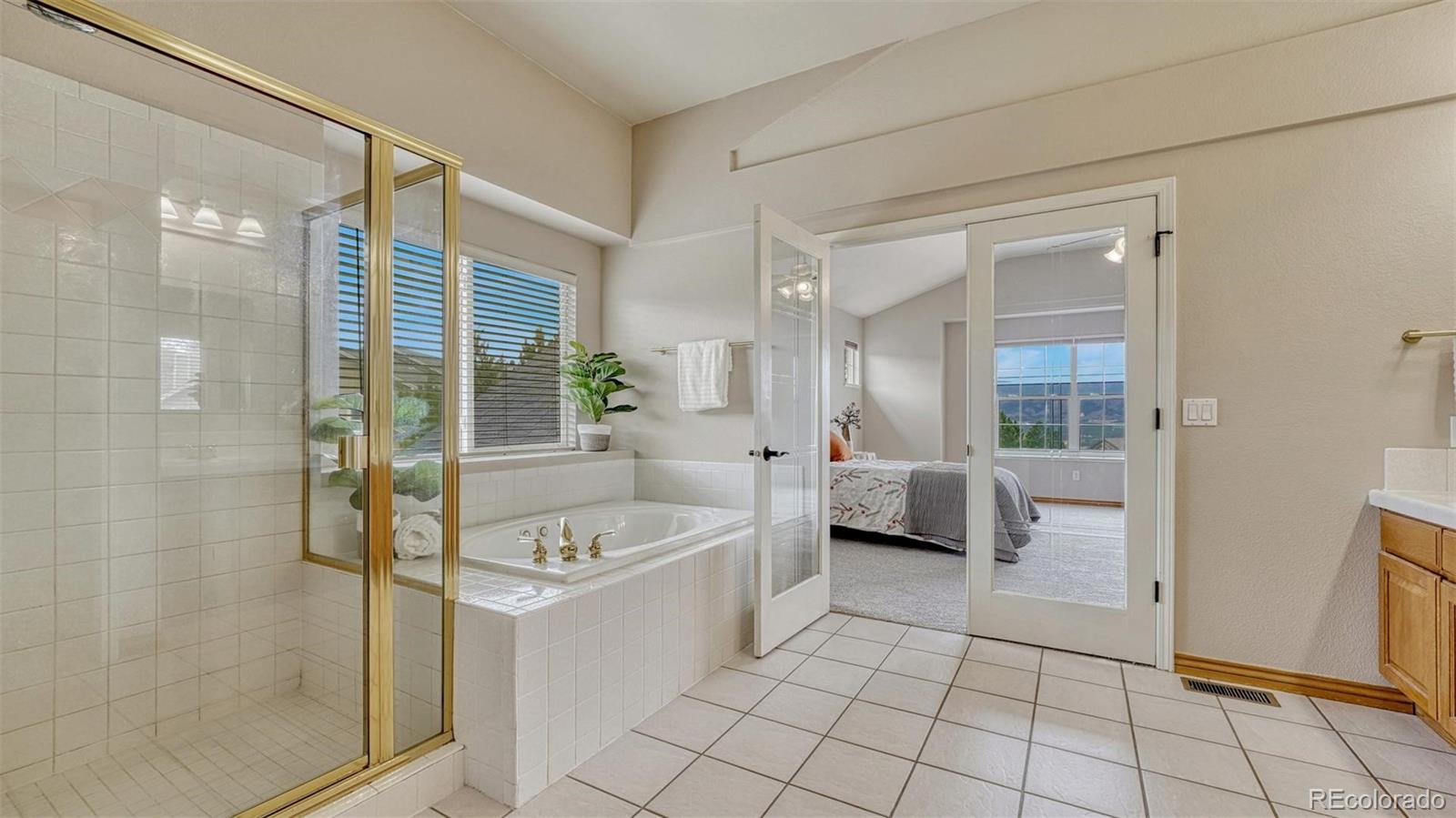 15211 Ridgefield Lane Colorado Springs, CO 80921 - Photo 22 of 47 a spacious bathroom with a tub shower and sink