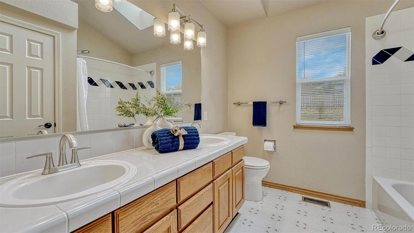 15211 Ridgefield Lane Colorado Springs, CO 80921 - Photo 26 of 47 a bathroom with a double vanity sink toilet and shower