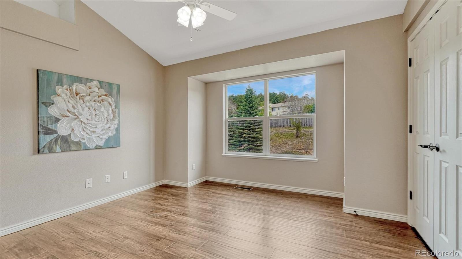 15211 Ridgefield Lane Colorado Springs, CO 80921 - Photo 27 of 47 a view of an empty room with wooden floor and a window