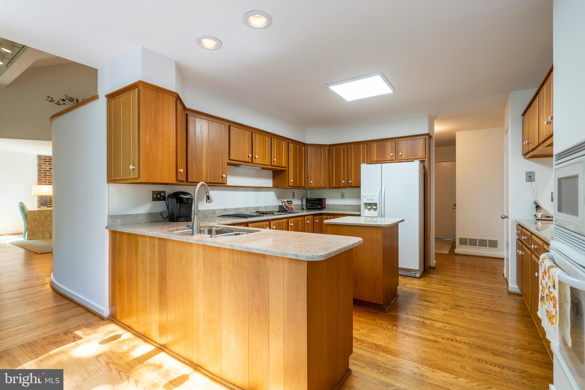 309 Valley Place Radnor, PA 19087 - Photo 16 of 39 a kitchen with stainless steel appliances granite countertop a refrigerator a sink dishwasher a stove with wooden cabinets and floor