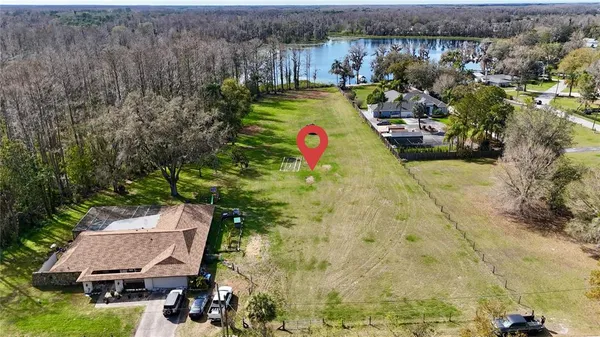 an aerial view of a house with swimming pool and lake view
