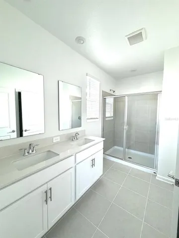 a bathroom with a double vanity sink mirror double and shower