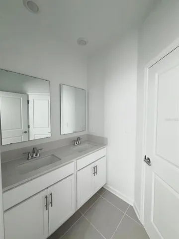 a bathroom with a double vanity sink and mirror
