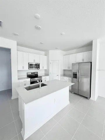 a kitchen with stainless steel appliances a refrigerator sink and microwave