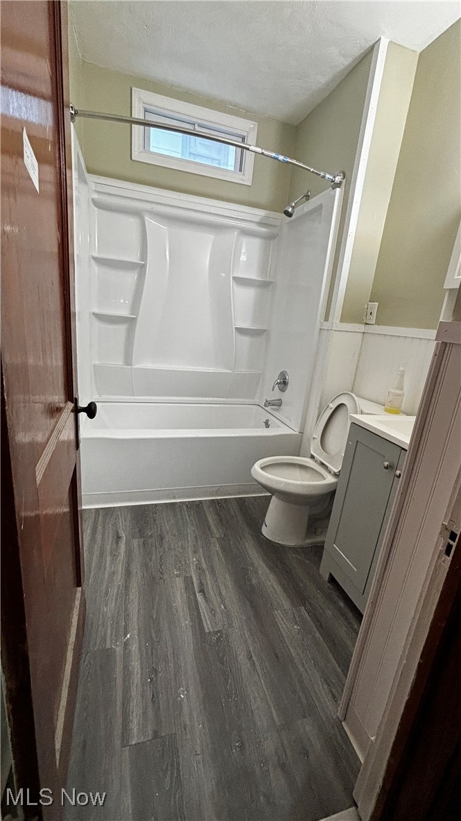 13421 Ashburton Road Cleveland, OH 44110 - Photo 10 of 28 Full bathroom with hardwood / wood-style flooring, a textured ceiling, vanity, bathtub / shower combination, and toilet