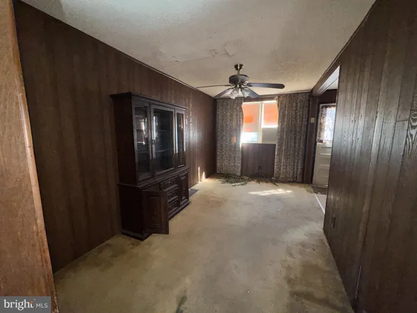a view of a livingroom with a chandelier fan and windows