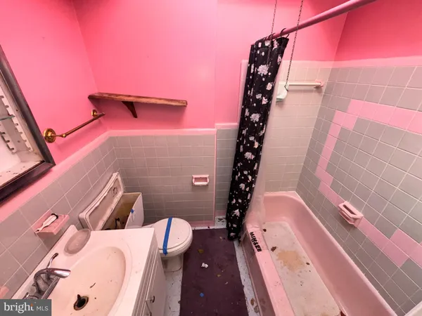 a bathroom with a toilet and a mirror