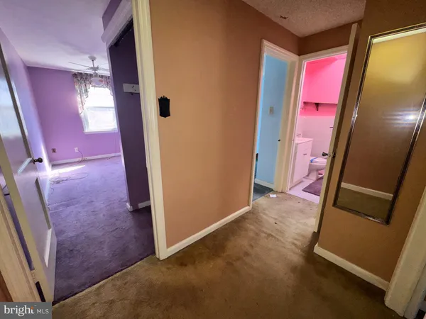 a view of an empty room with a chandelier fan