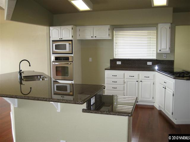 690 Tarn Way Reno, NV 89503 - Photo 5 of 13 a kitchen with granite countertop a sink a stove and cabinets