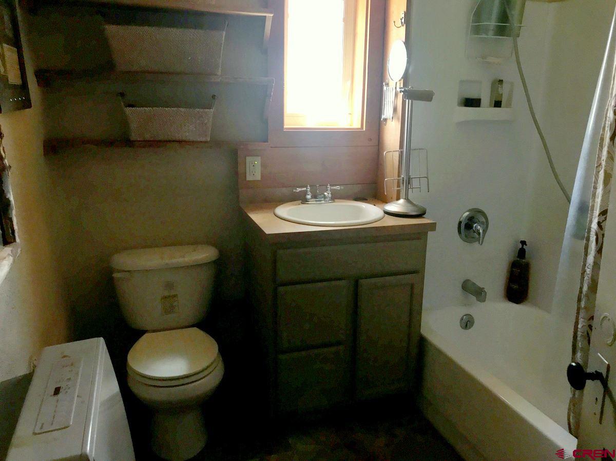 Tbd Shaw Creek Ranch Road Del Norte, CO 81132 - Photo 14 of 35 a bathroom with a toilet sink and mirror next to a window