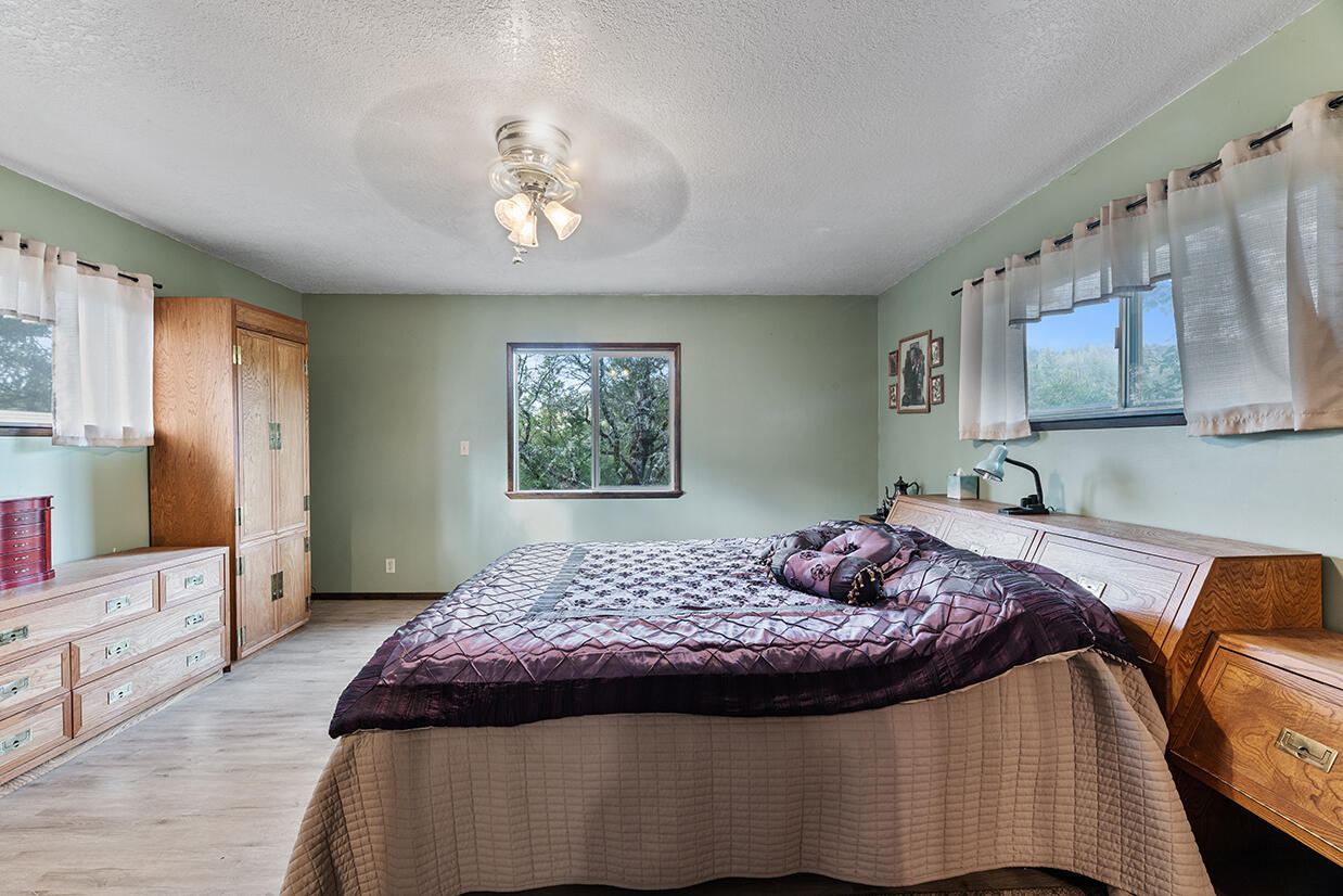 2900 Indian Creek Road Shady Cove, OR 97539 - Photo 13 of 35 a bedroom with a bed and a flat screen tv