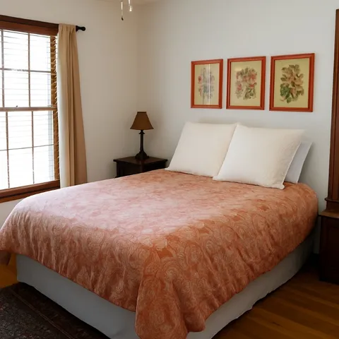 a large bed sitting in a bedroom next to a window