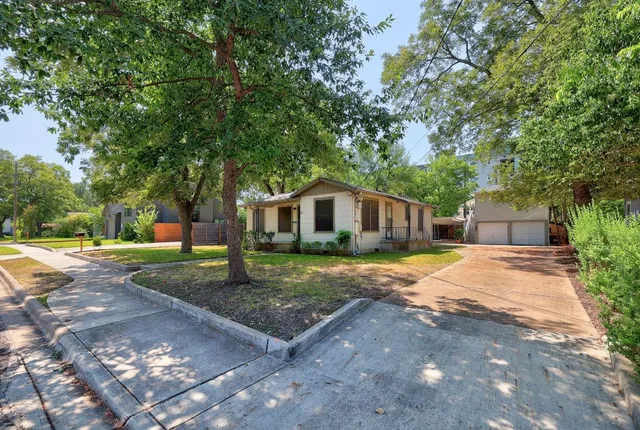 a front view of a house with yard tree and green space